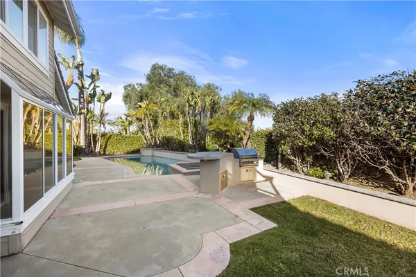 a view of a yard with plants and a bench