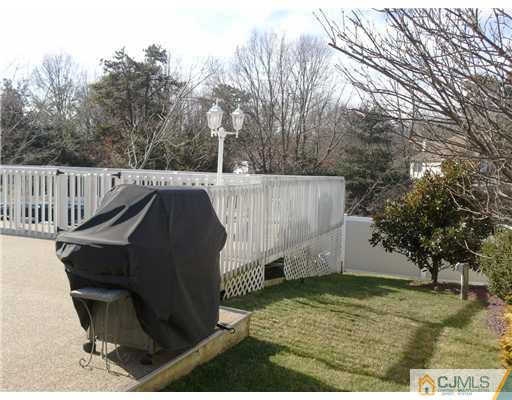 10 Bernadette Road Morganville, NJ 07751 - Photo 20 of 24 a view of backyard with wooden fence and trees