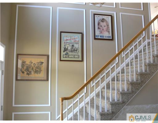 10 Bernadette Road Morganville, NJ 07751 - Photo 3 of 24 a view of staircase with wooden floor and painting on the wall