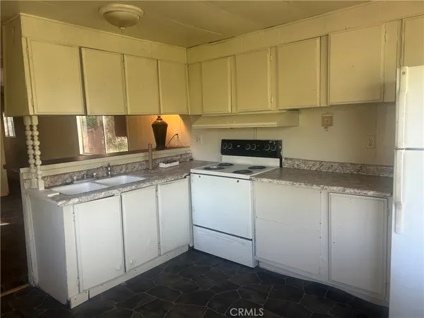 a kitchen with a refrigerator sink and cabinets
