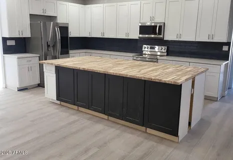 a kitchen with a refrigerator sink and cabinets