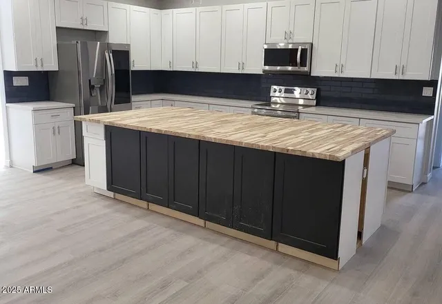 a kitchen with a refrigerator sink and cabinets