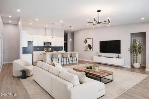 a living room with furniture a flat screen tv and kitchen view