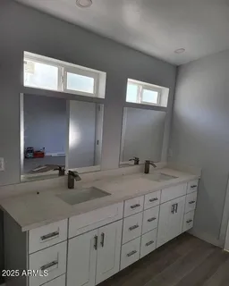 a bathroom with double sink and a mirror