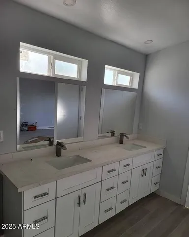 a bathroom with double sink and a mirror