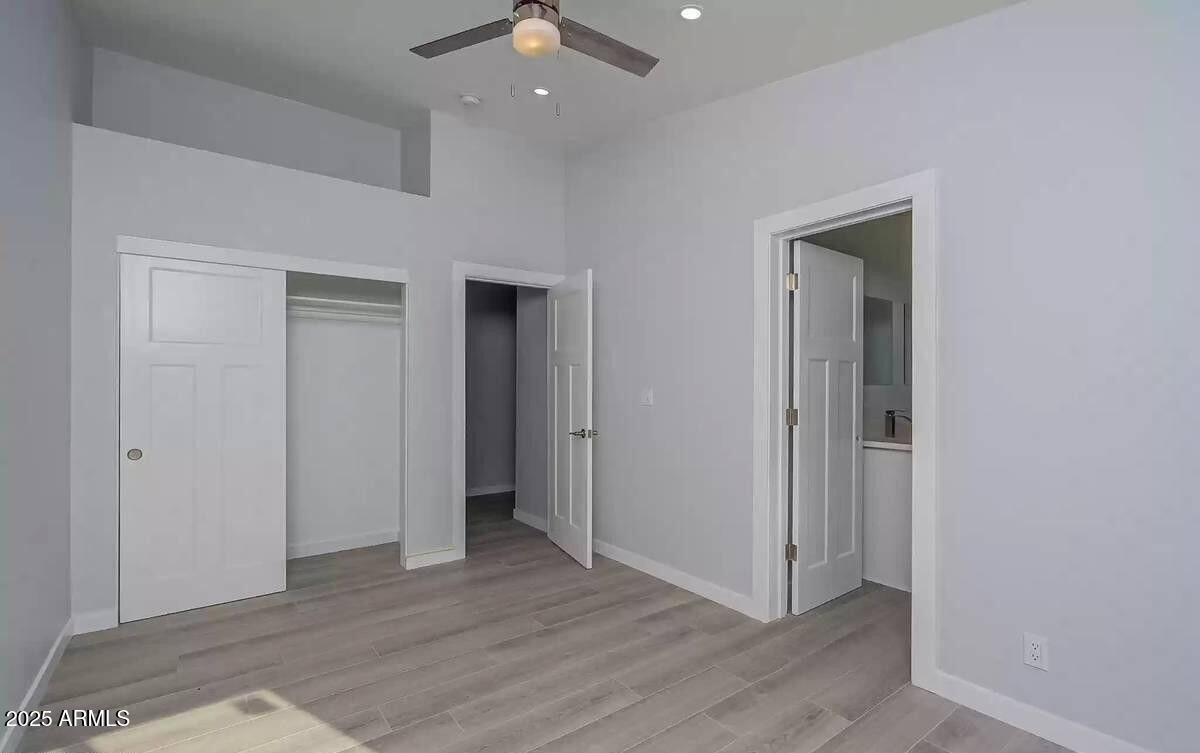 2511 East Broadway Road Phoenix, AZ 85040 - Photo 13 of 17 an empty room with wooden floor and closet
