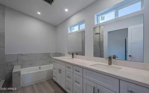 a bathroom with a tub sink and mirror