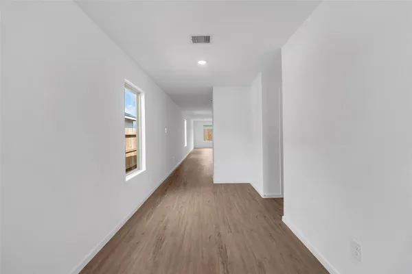 a view of a big room with wooden floor and windows