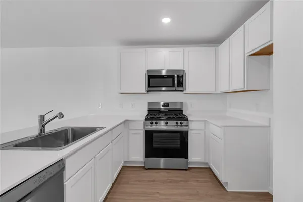 a kitchen with sink a stove and microwave