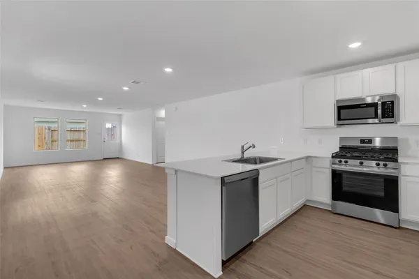 a kitchen with stainless steel appliances granite countertop a sink stove and microwave