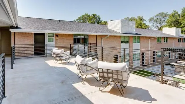 a view of a patio with couches chairs and wooden floor