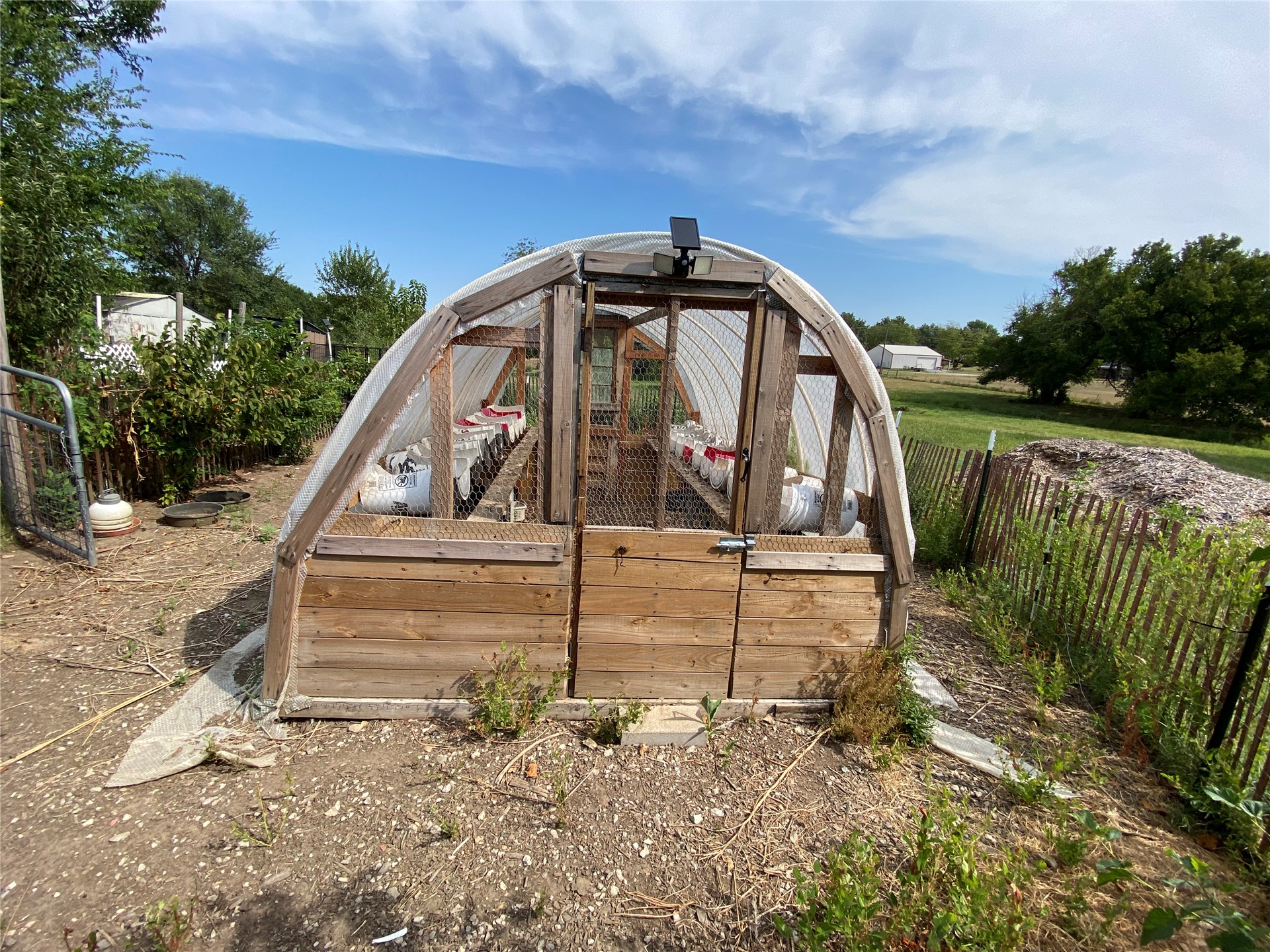 11131 215th Road Nowata, OK 74048 - Photo 30 of 47 Greenhouse structure with a wooden base and arched translucent covering