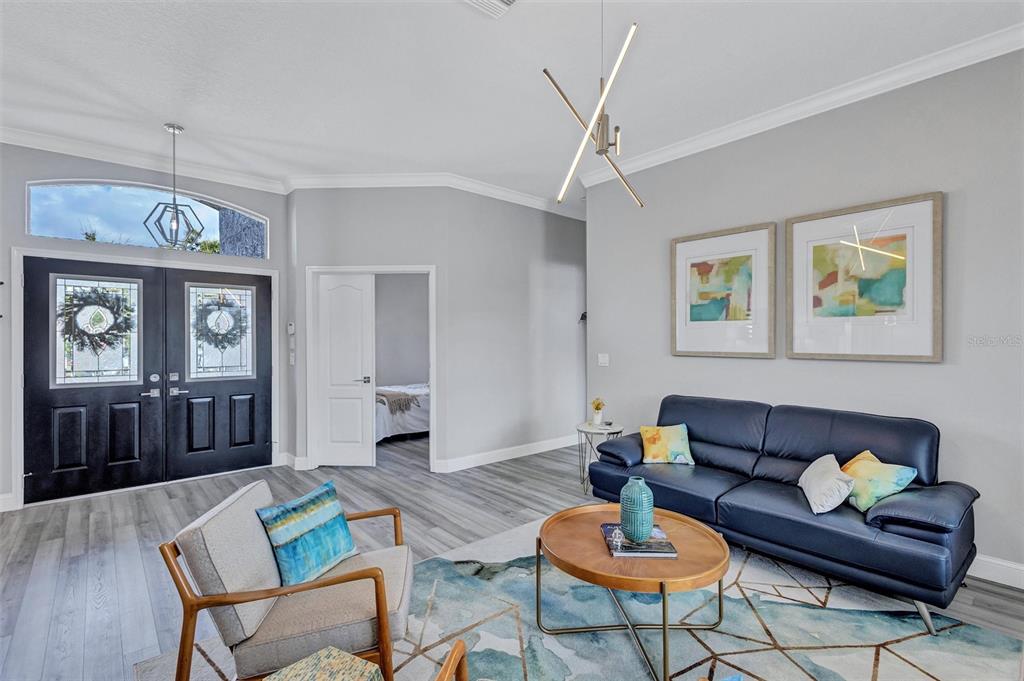 8409 29th Street East Parrish, FL 34219 - Photo 9 of 65 a living room with furniture a window and a chandelier