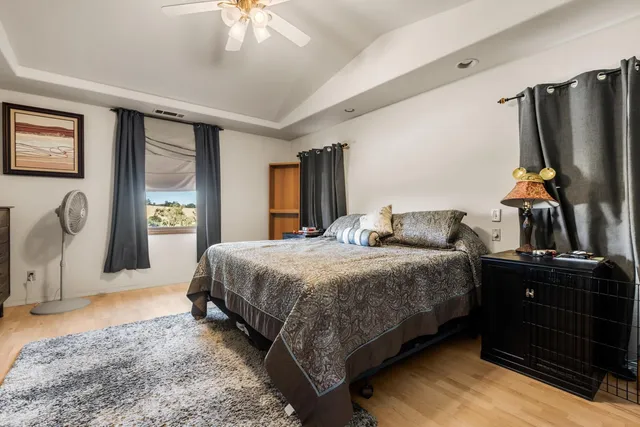 a bedroom with a bed dresser and a flat tv screen