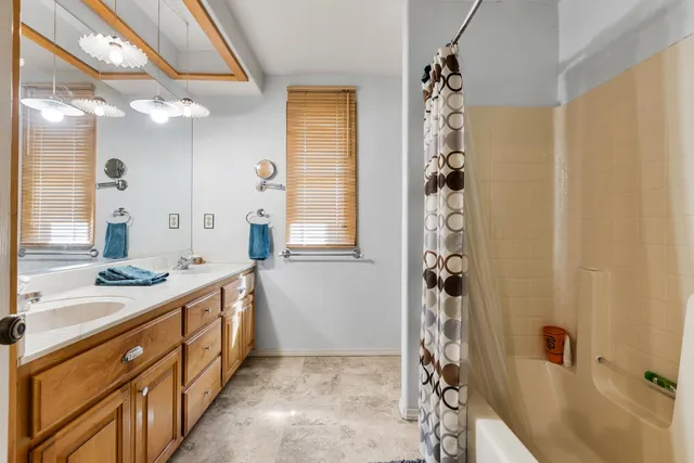 a bathroom with a double vanity sink a mirror a shower and a bathtub