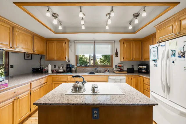 a kitchen with granite countertop a sink stove and refrigerator