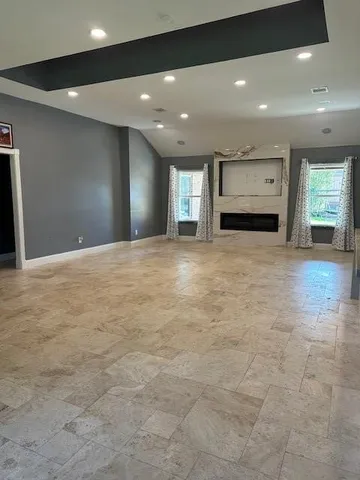 a view of an empty room with window and fireplace