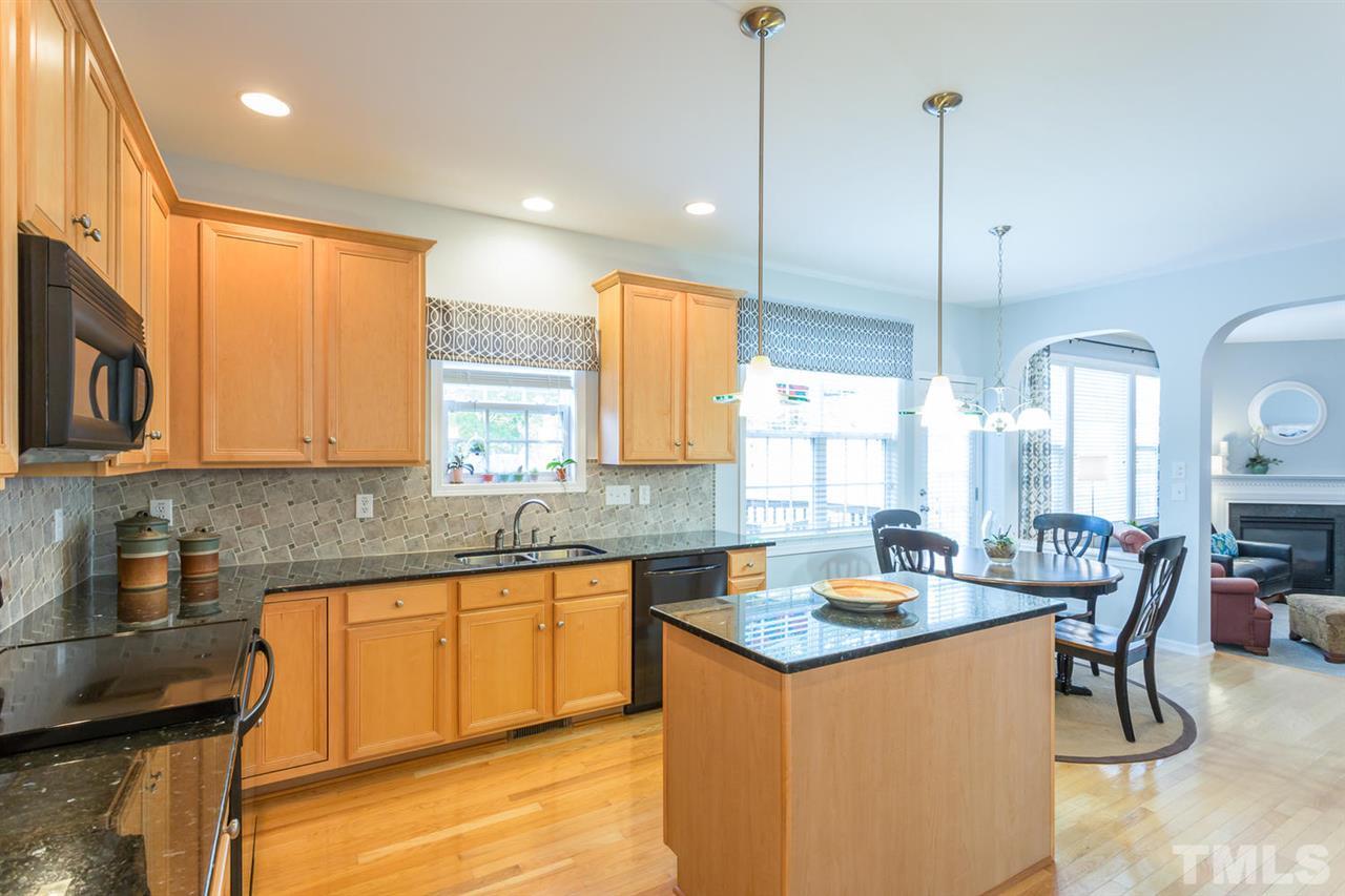 8609 Benzinger Drive Raleigh, NC 27613 - Photo 8 of 25 a kitchen with stainless steel appliances granite countertop a sink a stove and a wooden floors