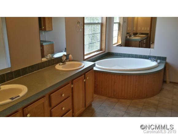 91 Austin Road Clyde, NC 28721 - Photo 18 of 23 a bathroom with a sink a mirror and a bathtub