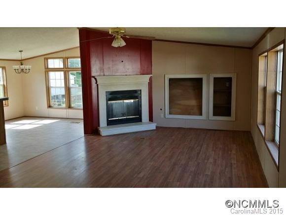 91 Austin Road Clyde, NC 28721 - Photo 8 of 23 a open hall with a fireplace and wooden floor