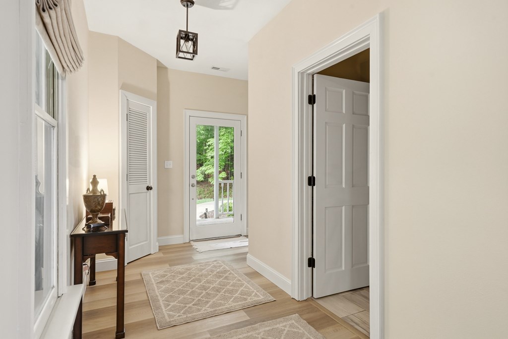175 Crane Creek Road Young Harris, GA 30582 - Photo 8 of 40 a view of a hallway with wooden floor and a livingroom with furniture