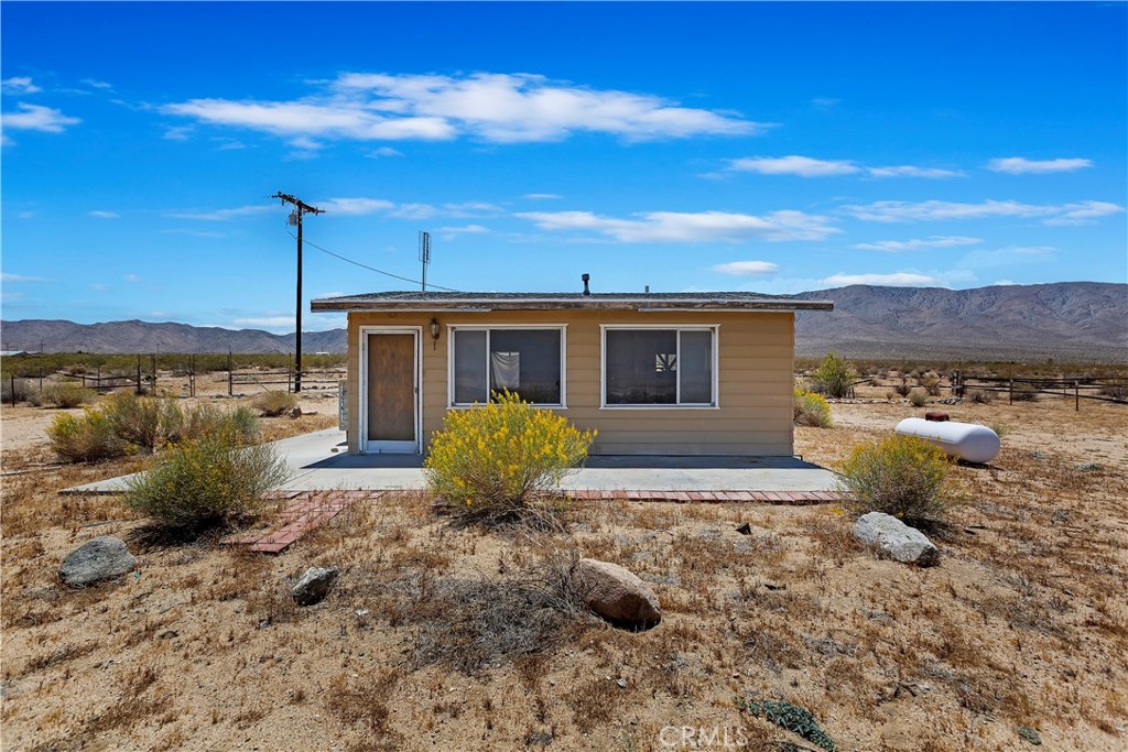 a view of a house with backyard sitting area and garden