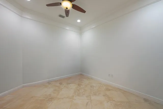 a view of an empty room with a chandelier fan