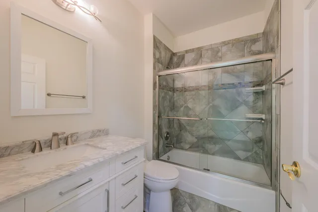 a bathroom with a granite countertop sink toilet and shower
