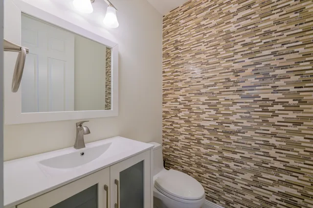 a bathroom with a sink a toilet and mirror