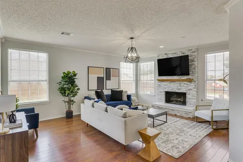 a living room with furniture a fireplace and a flat screen tv