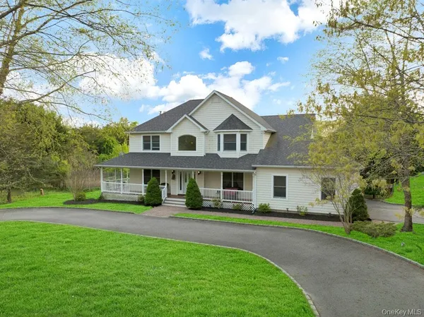 a front view of a house with a garden and trees