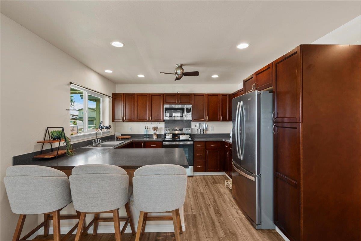 214 Alake Street Kahului, HI 96732 - Photo 12 of 27 a kitchen with refrigerator a sink and chairs