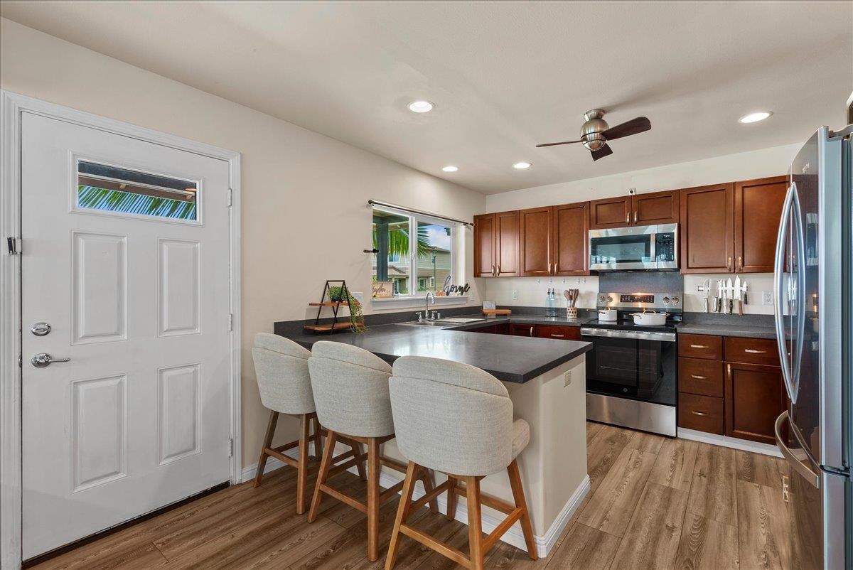 214 Alake Street Kahului, HI 96732 - Photo 13 of 27 a kitchen with granite countertop wooden floors appliances and cabinets