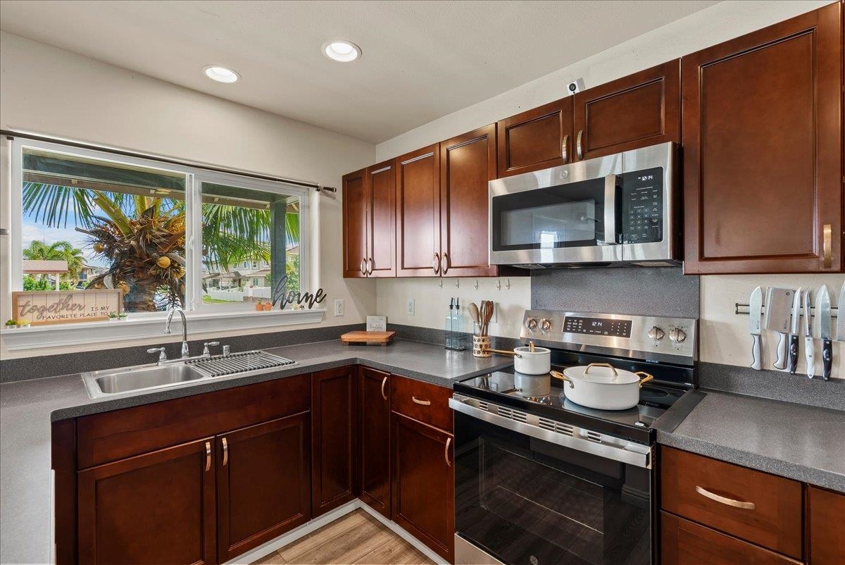 214 Alake Street Kahului, HI 96732 - Photo 16 of 27 a kitchen with stainless steel appliances granite countertop wooden cabinets sink and window