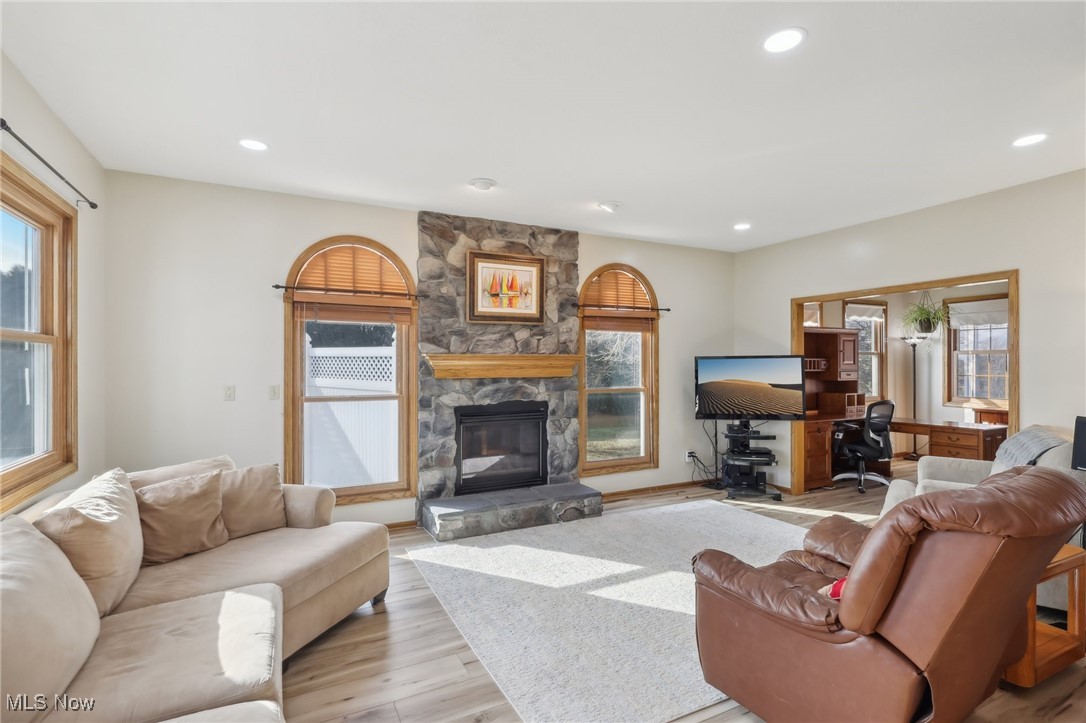 5475 Windfall Road Medina, OH 44256 - Photo 7 of 41 Living room featuring a stone fireplace and a wealth of natural light.Opens to Kitchen.