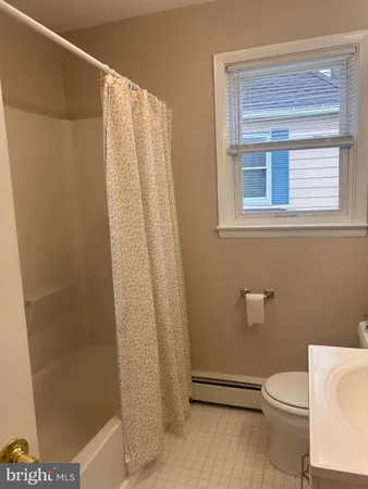 a white toilet sitting next to a shower