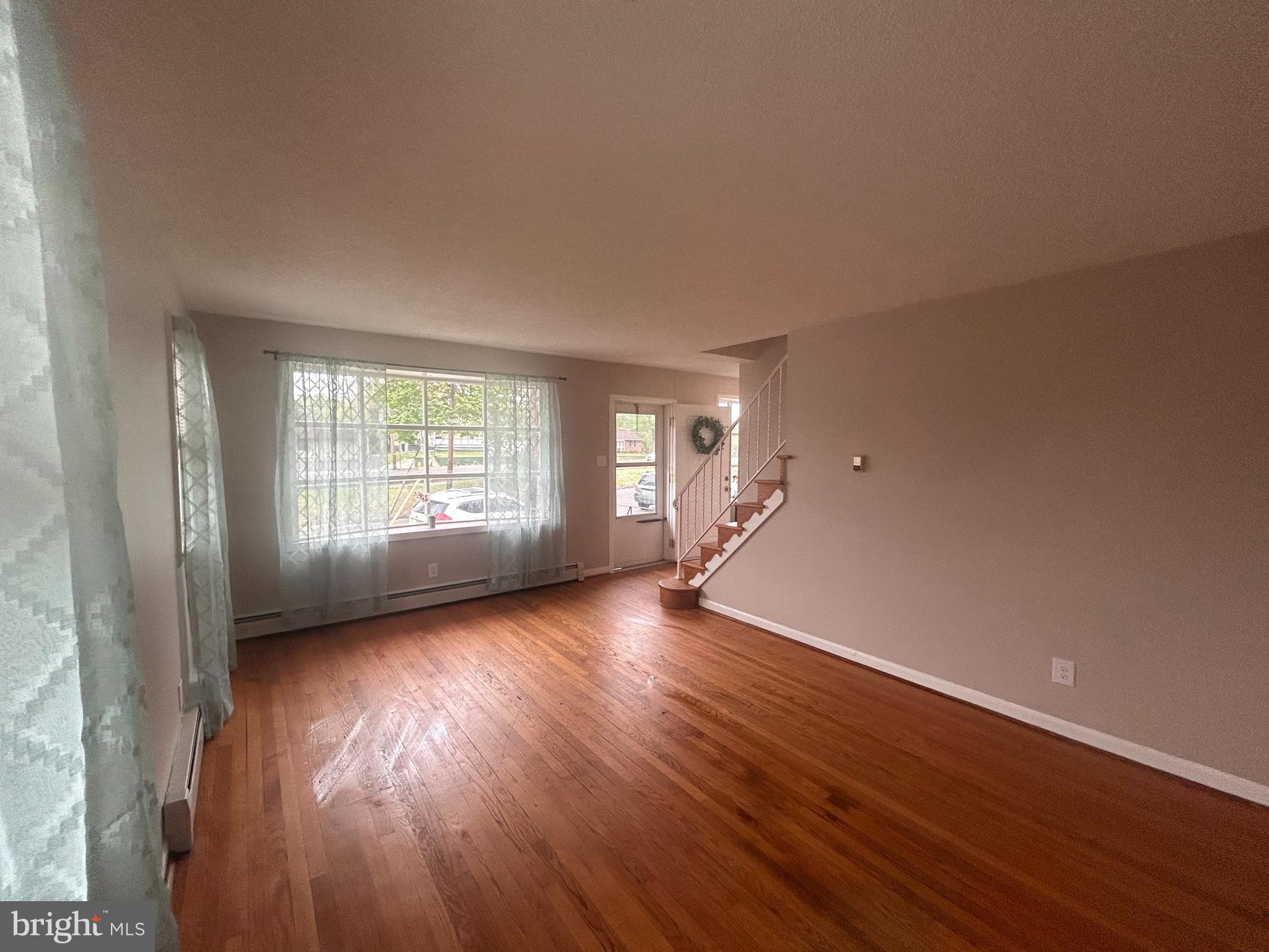 300 Evesham Avenue West Magnolia, NJ 08049 - Photo 6 of 25 an empty room with wooden floor and windows