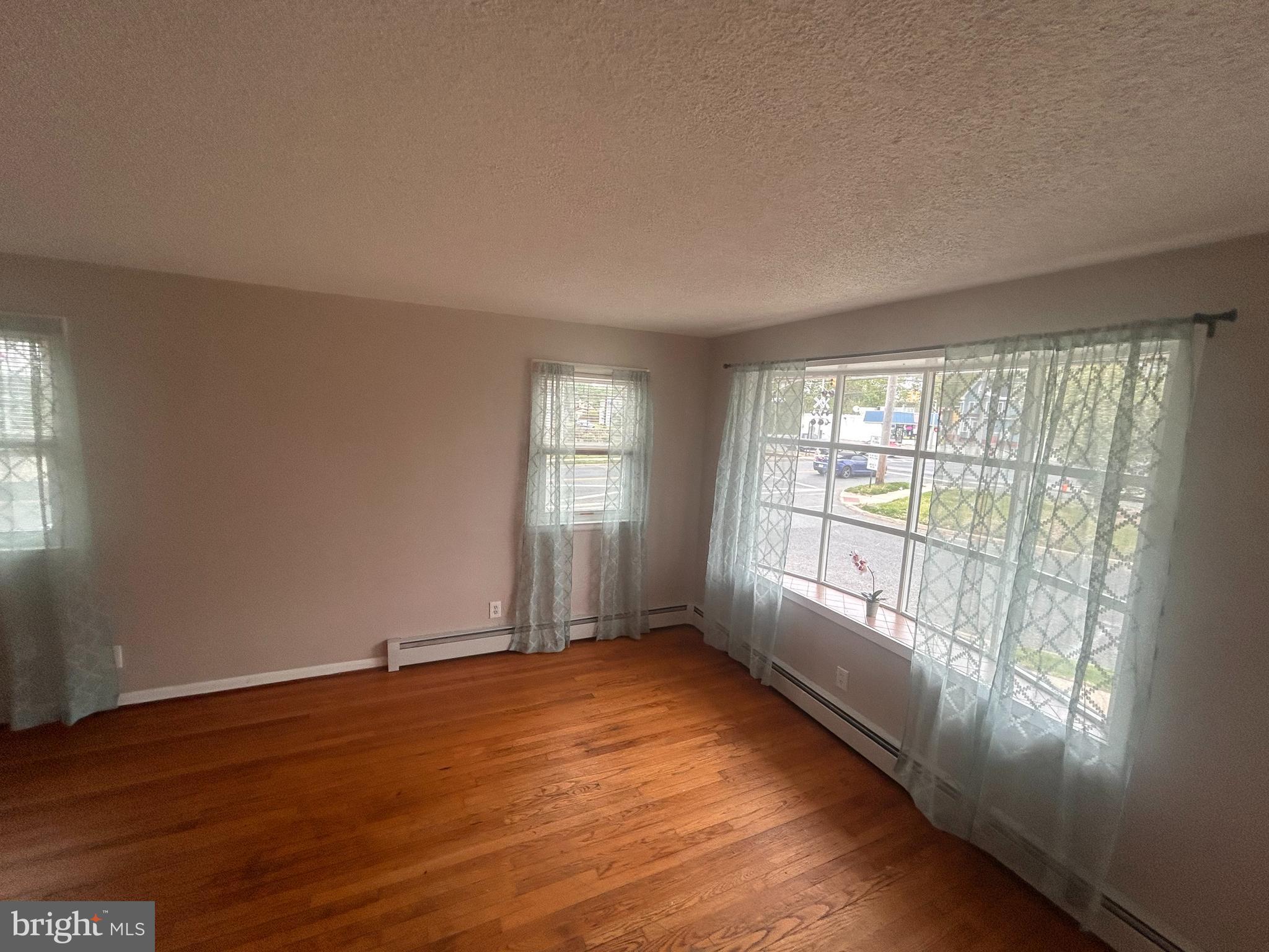 300 Evesham Avenue West Magnolia, NJ 08049 - Photo 7 of 25 a view of an empty room with wooden floor and a window