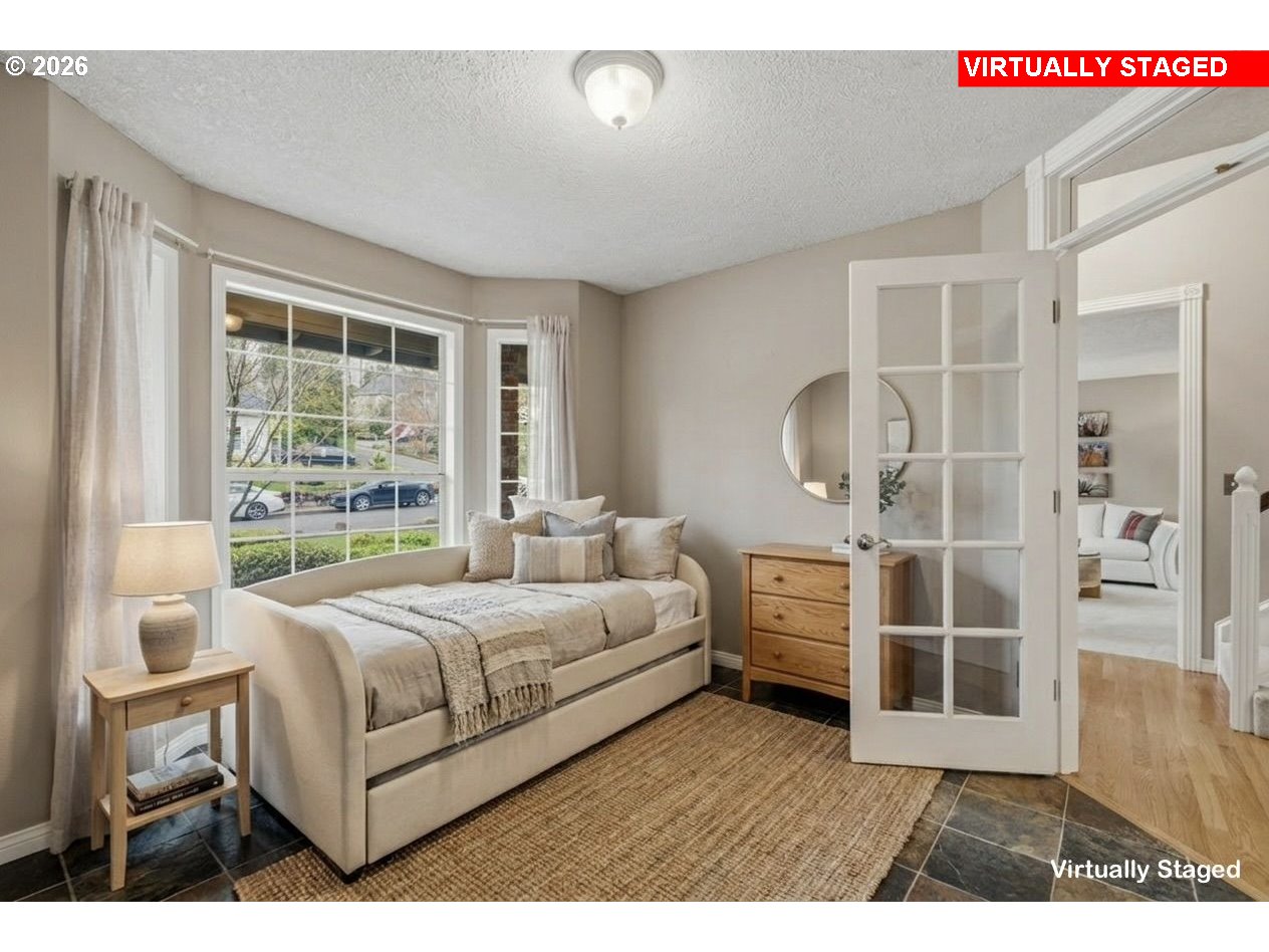6108 Southwest Kruse Ridge Drive Portland, OR 97219 - Photo 20 of 42 a bedroom with a large bed and wooden floor