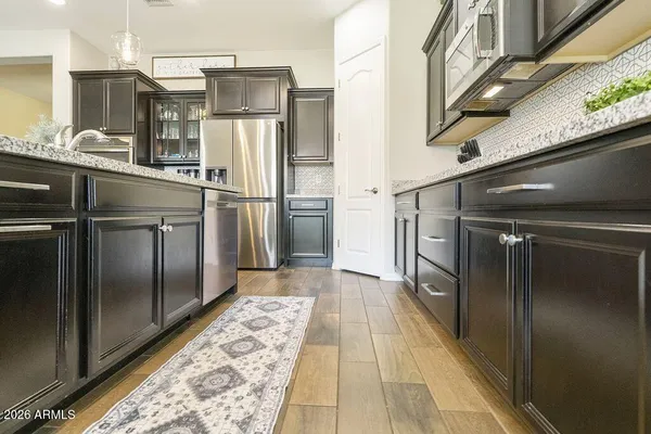 a kitchen with stainless steel appliances granite countertop a refrigerator and a sink