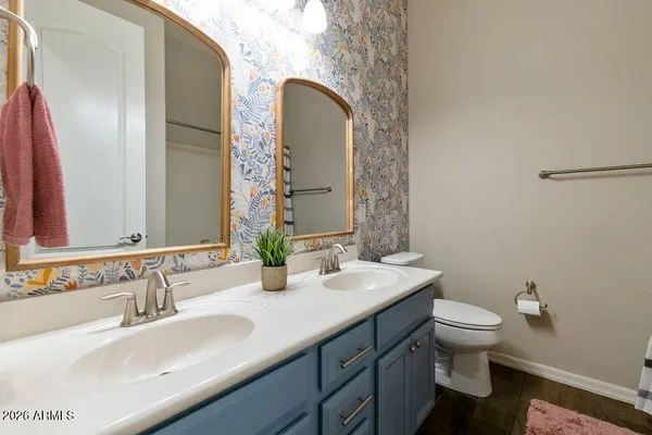 a bathroom with a granite countertop toilet a sink and a mirror