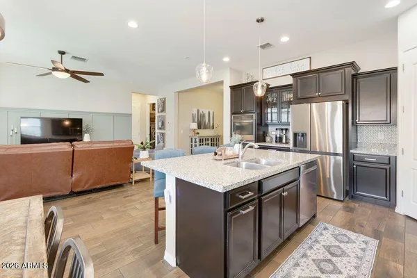 a kitchen with a sink stainless steel appliances and ceiling fan
