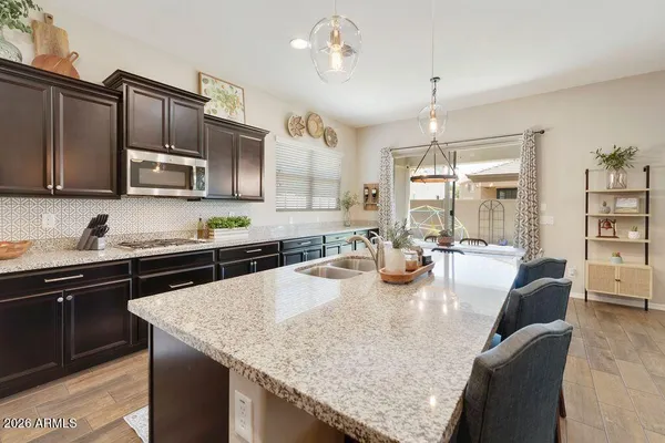a kitchen with granite countertop kitchen island stainless steel appliances a stove sink microwave and cabinets