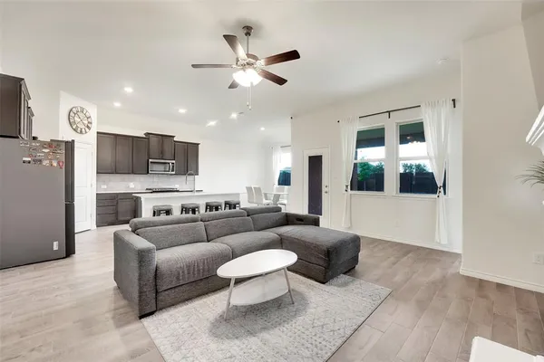 a living room with furniture and a view of kitchen