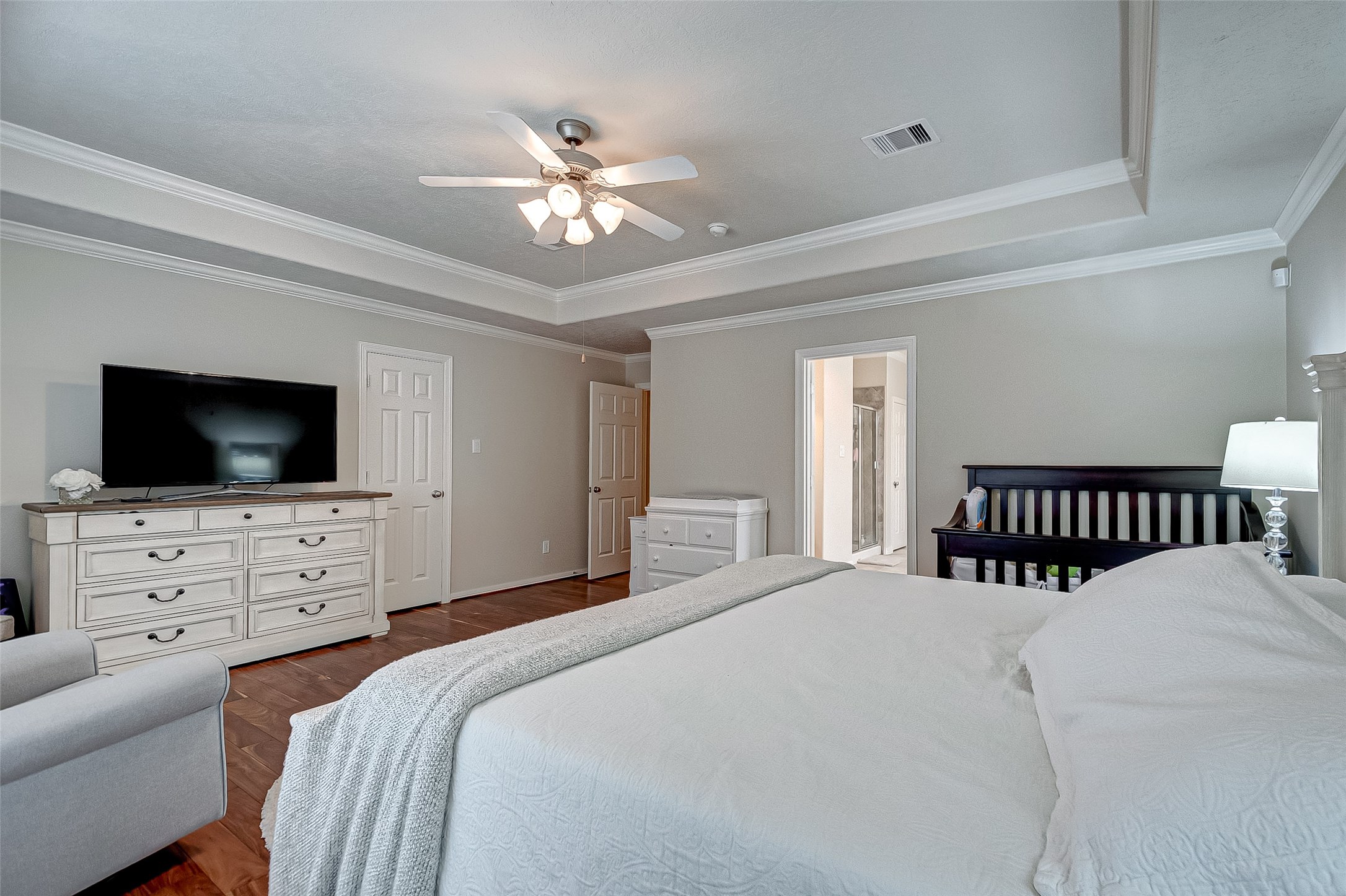 14418 Basalt Lane Houston, TX 77077 - Photo 20 of 32 a bedroom with a large bed a flat tv screen and a chandelier
