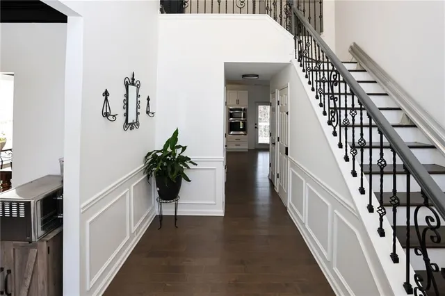 a view of staircase with lots of frames on wall and wooden floor