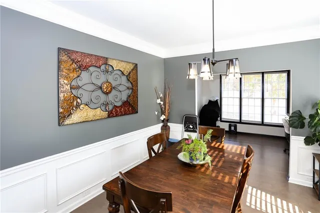a dining room with furniture a chandelier and wooden floor