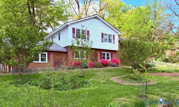 a front view of a house with yard and trees