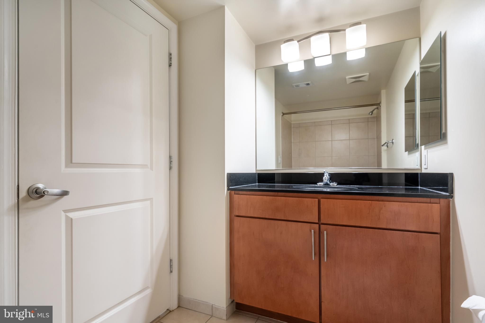 915 E Street Northwest, Unit 103 Washington, DC 20004 - Photo 11 of 43 a bathroom with a mirror and a sink