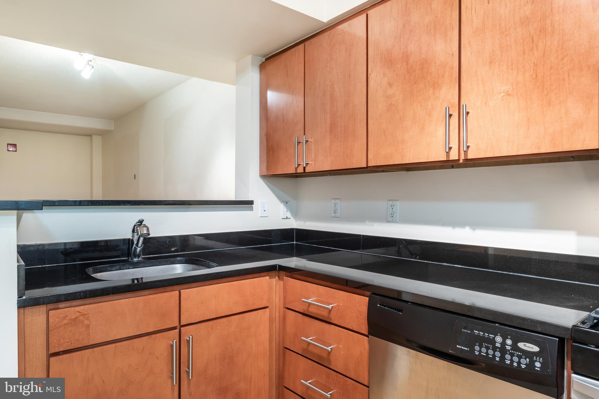 915 E Street Northwest, Unit 103 Washington, DC 20004 - Photo 17 of 43 a kitchen with granite countertop a sink and cabinets